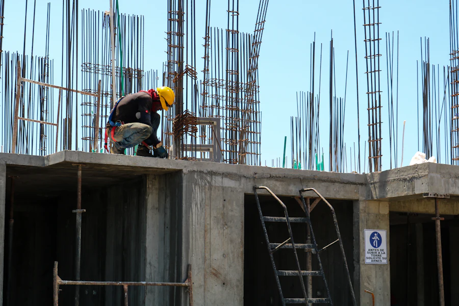 Workers tying rebar on a concrete deck between columns of a rising building
