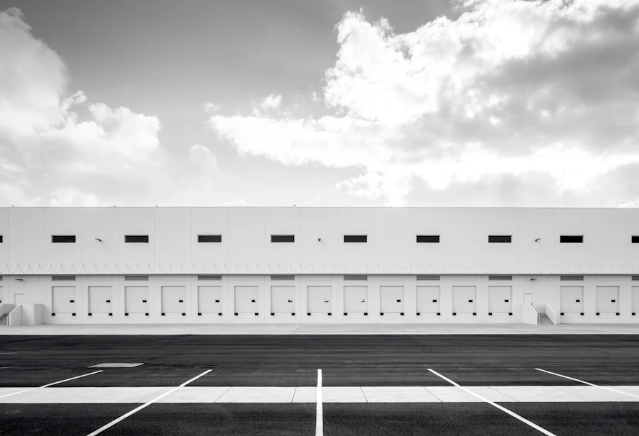 Long white distribution warehouse with a row of loading docks, in black and white