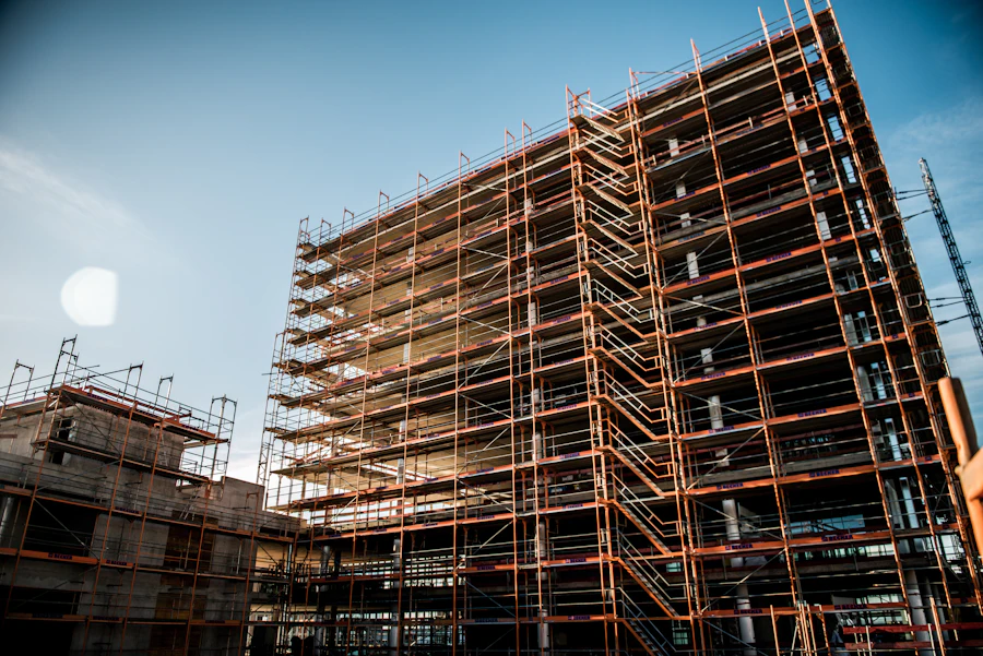 Brick building wrapped in scaffolding under a blue sky
